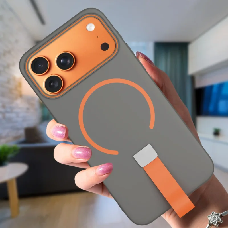 Szare etui do iPhone 17 Pro / 18 Pro z pierścieniem do MagSafe i paskiem na palec pokazane w dłoni