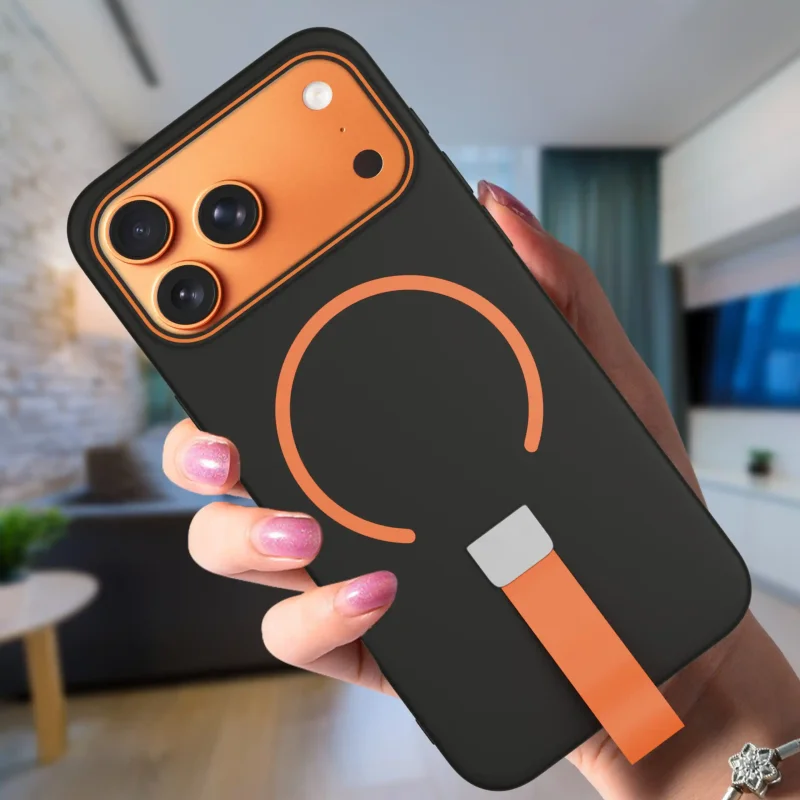 Czarne etui do iPhone 17 Pro / 18 Pro z pierścieniem do MagSafe i pomarańczowym paskiem pokazane w dłoni