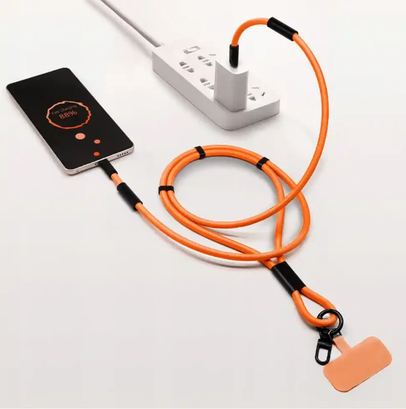 Pomarańczowa smycz do telefonu z kablem USB-C 60W podłączona do smartfona i ładowarki sieciowej podczas ładowania