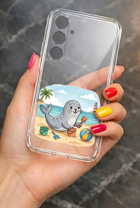 Przezroczyste etui letnie do Samsung Galaxy S24 FE z nadrukiem foki bawiącej się na plaży, prezentowane w dłoni