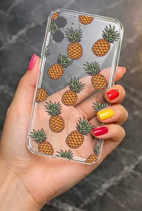 Przezroczyste etui letnie do iPhone 11 z nadrukiem ananasów, prezentowane w dłoni