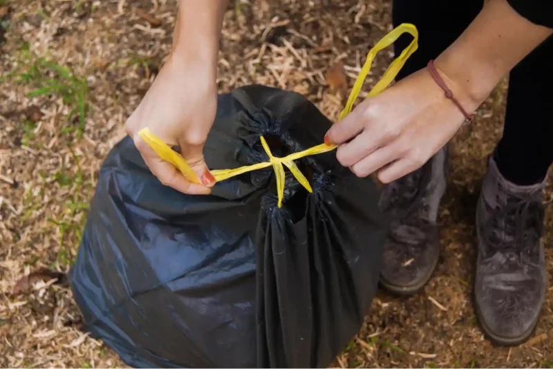 Zamykanie pełnego worka Paclan Eco Line 60 l za pomocą żółtej taśmy ściągającej