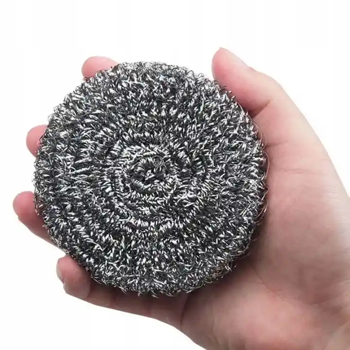 Metalowy zmywak spiralny trzymany w dłoni