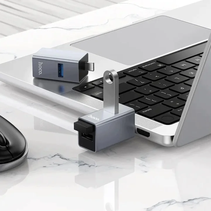 Hub Hoco USB-C 3w1 przy laptopie z trzema portami USB-A do podłączania akcesoriów