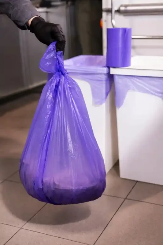Zawiązany worek na śmieci Paclan Expert 35 L podczas wynoszenia odpadów
