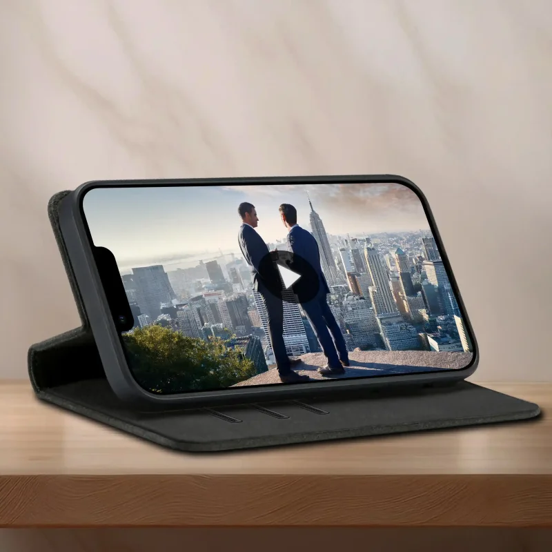 Czarne etui z klapką do iPhone 13 | 14 ustawione jako stojak do oglądania filmu na telefonie