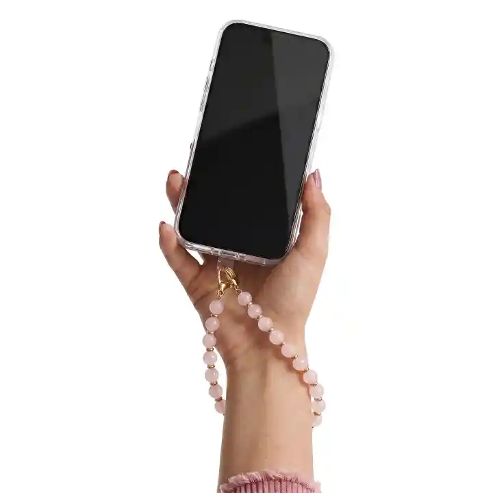 Różowa koralikowa zawieszka do telefonu przypięta do etui i przewieszona przez nadgarstek