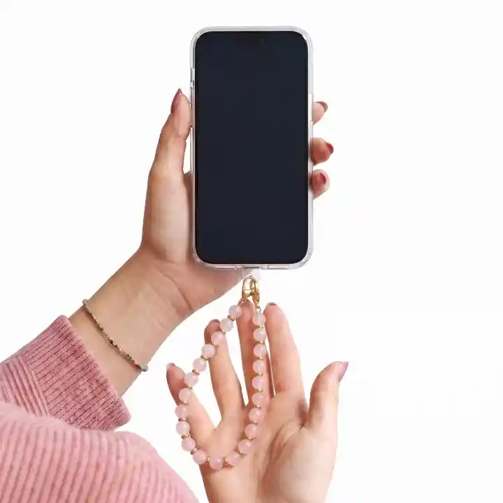 Zawieszka do telefonu z różowymi koralikami trzymana przy smartfonie jako smycz na nadgarstek
