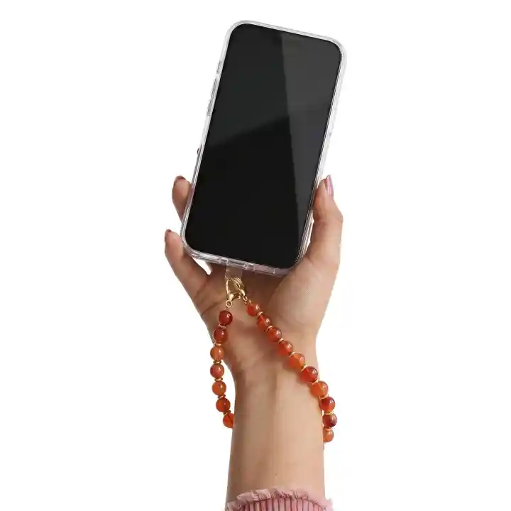 Brązowa koralikowa zawieszka do telefonu przypięta do etui i przewieszona przez nadgarstek