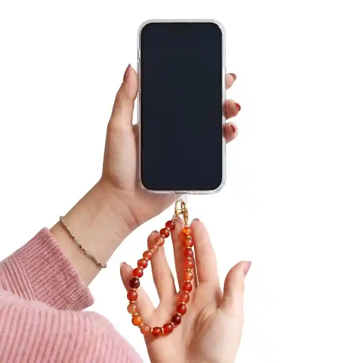Brązowa zawieszka do telefonu z koralikami trzymana przy smartfonie jako smycz na nadgarstek