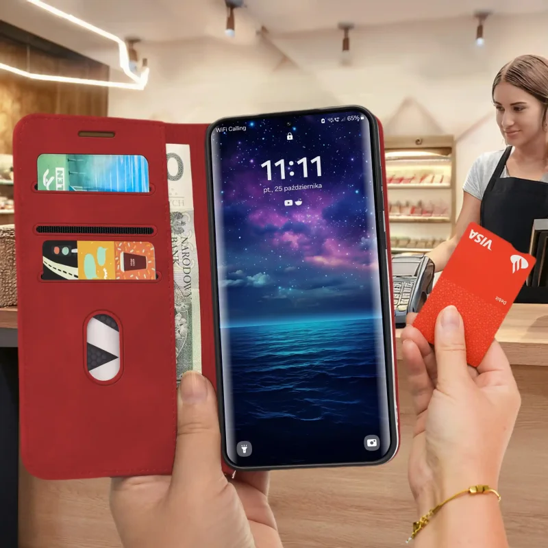 Czerwone etui Velvet do Motorola Edge 70 Fusion trzymane w dłoni podczas płatności kartą, z widocznymi kieszonkami i przegrodą na banknot